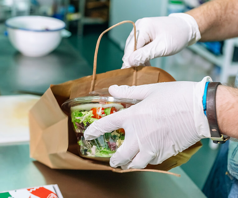 food worker putting a salad into a twist handle bag